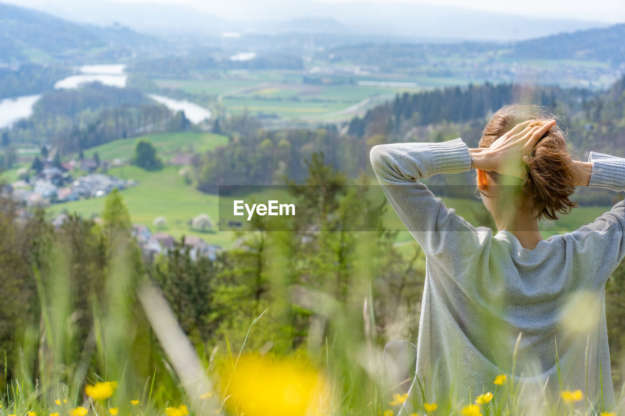 Rear view of woman sitting on mountain