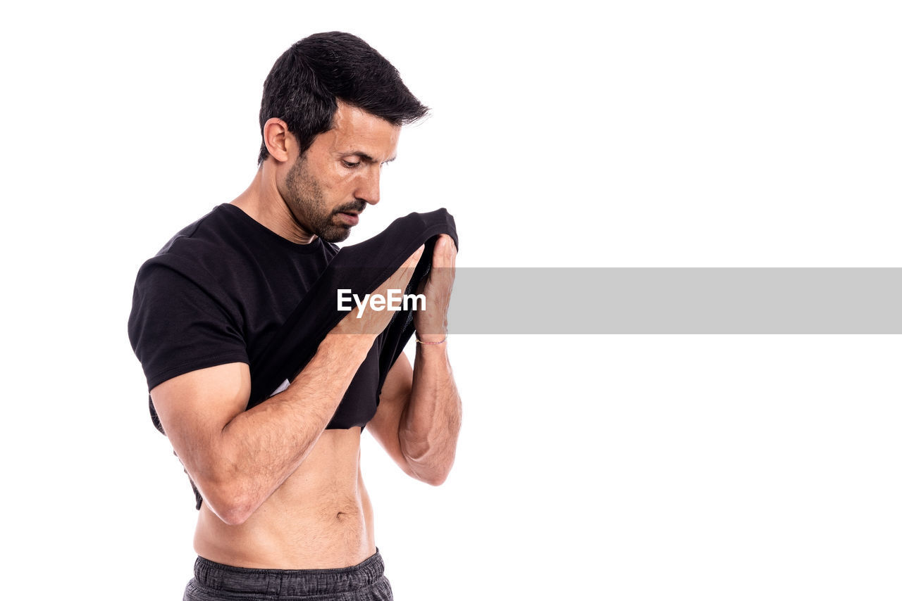 MAN STANDING AGAINST WHITE BACKGROUND