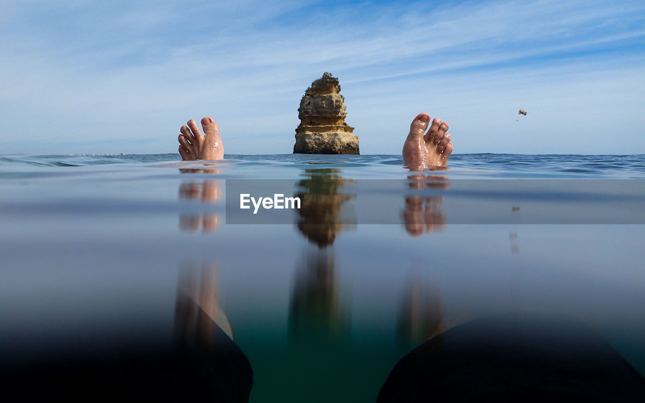 Rock formations in sea against blue sky