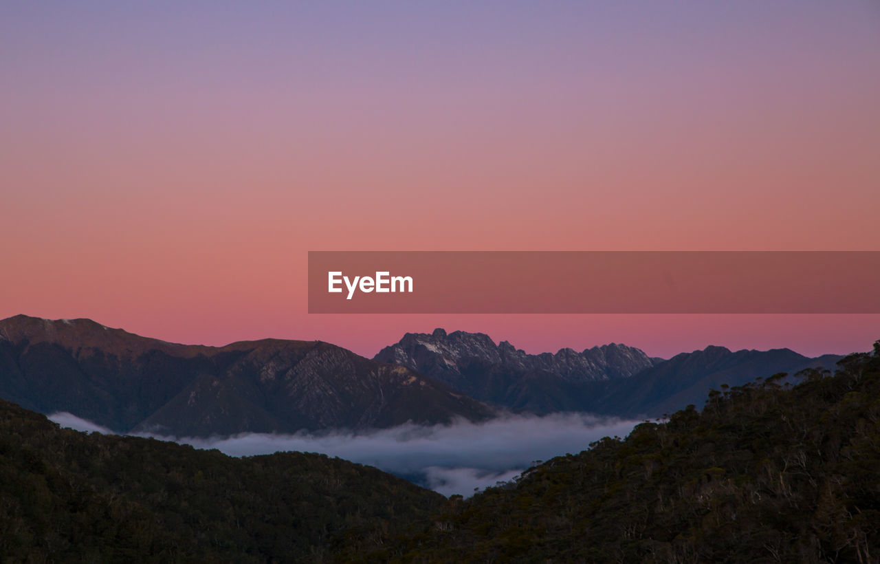 Scenic view of mountains against romantic sky at sunset