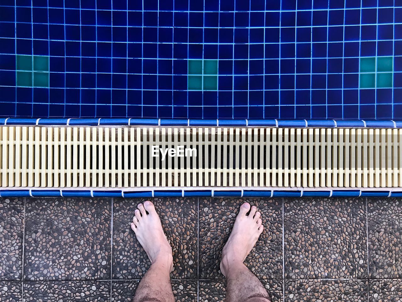 Low section of man standing at poolside