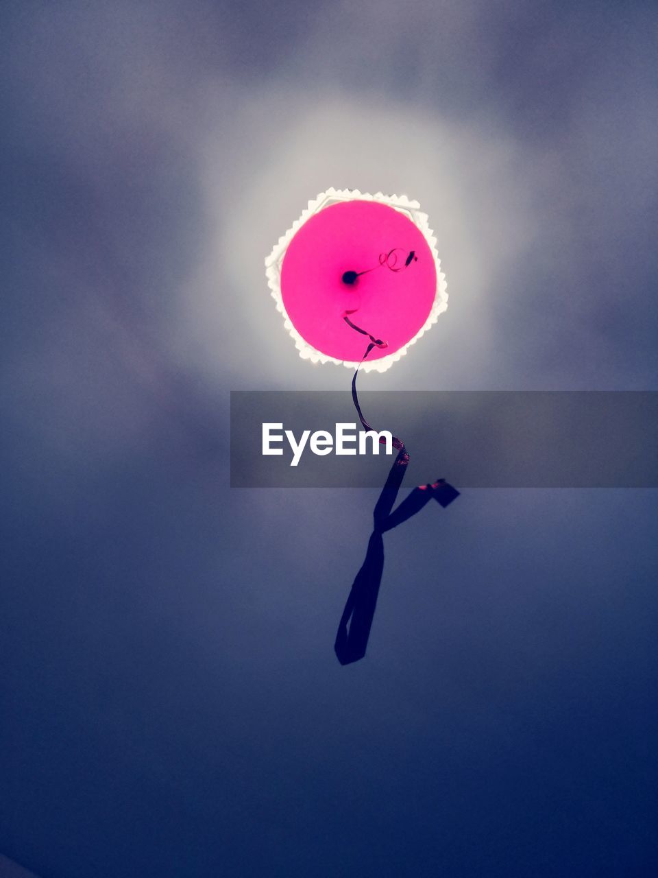 Low angle view of pink balloon flying against sky