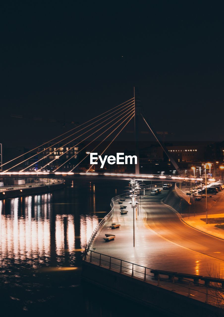 Illuminated bridge against sky at night