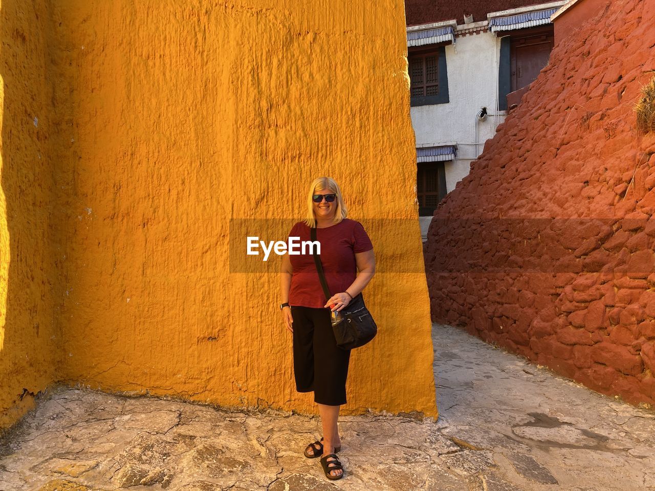 Full length of woman standing against wall in building orange and red 