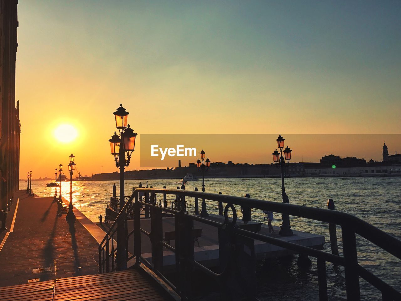 Pier on sea against sky during sunset