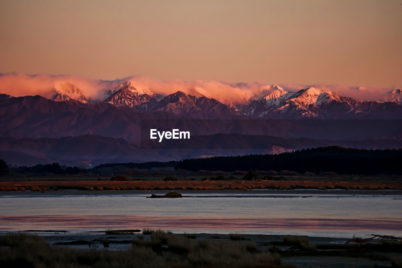 Scenic view of snowcapped mountains against sky during sunset