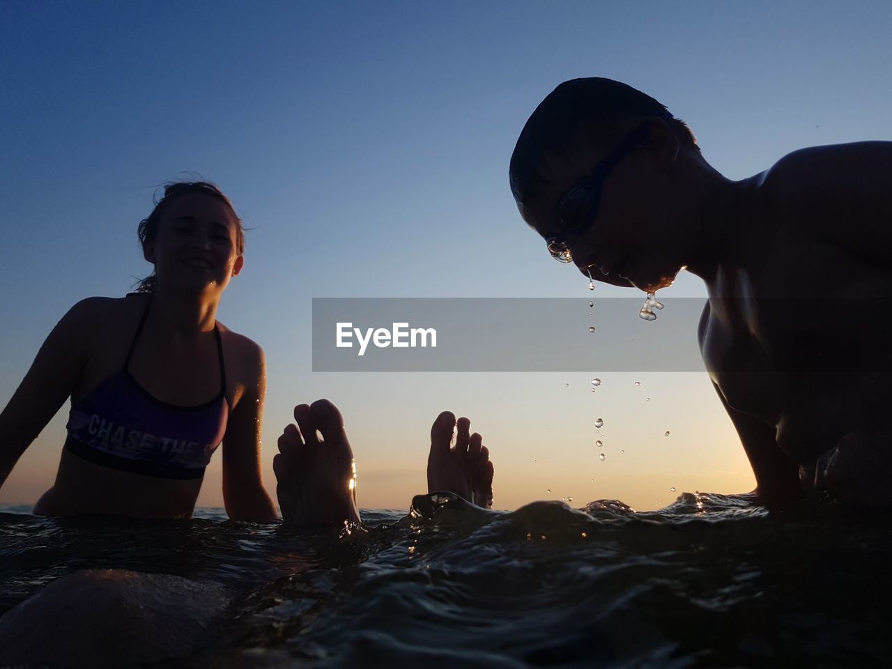 PEOPLE AT SEA SHORE AGAINST CLEAR SKY