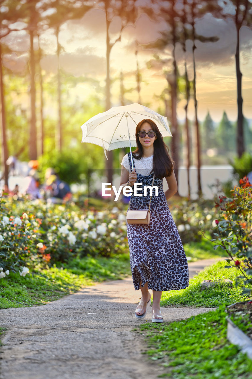 Full length of woman with umbrella standing in prak