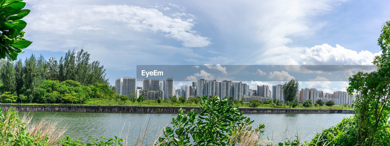 PANORAMIC VIEW OF BUILDINGS AND TREES AGAINST SKY