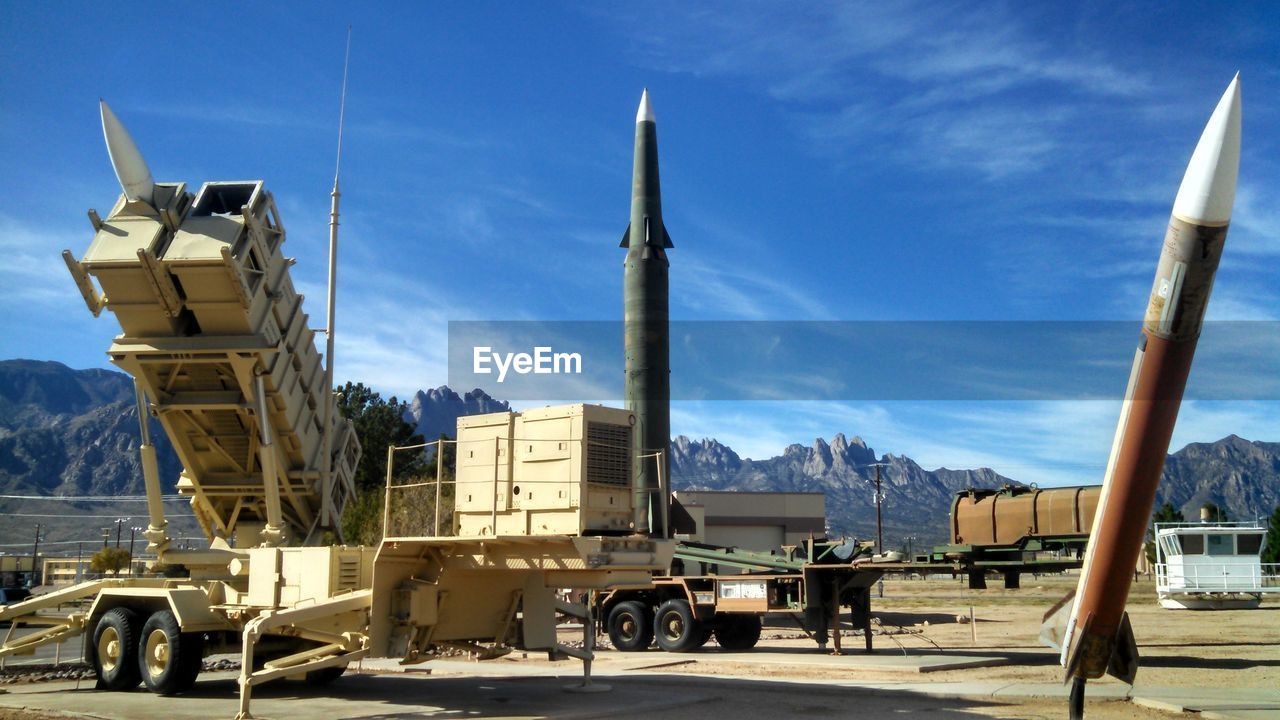 Rocket launcher and missiles at military base against sky