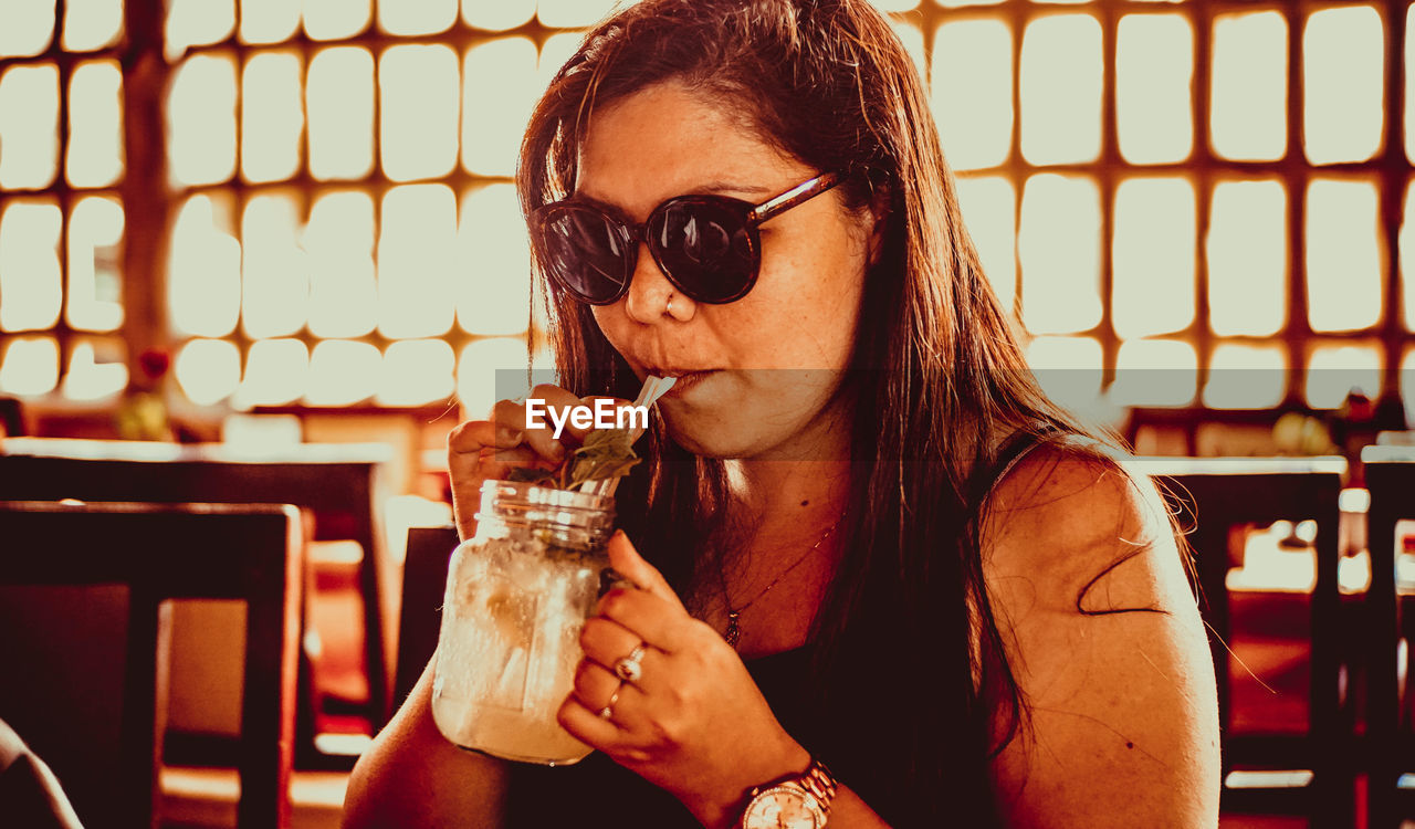 Woman drinking smoothie at restaurant