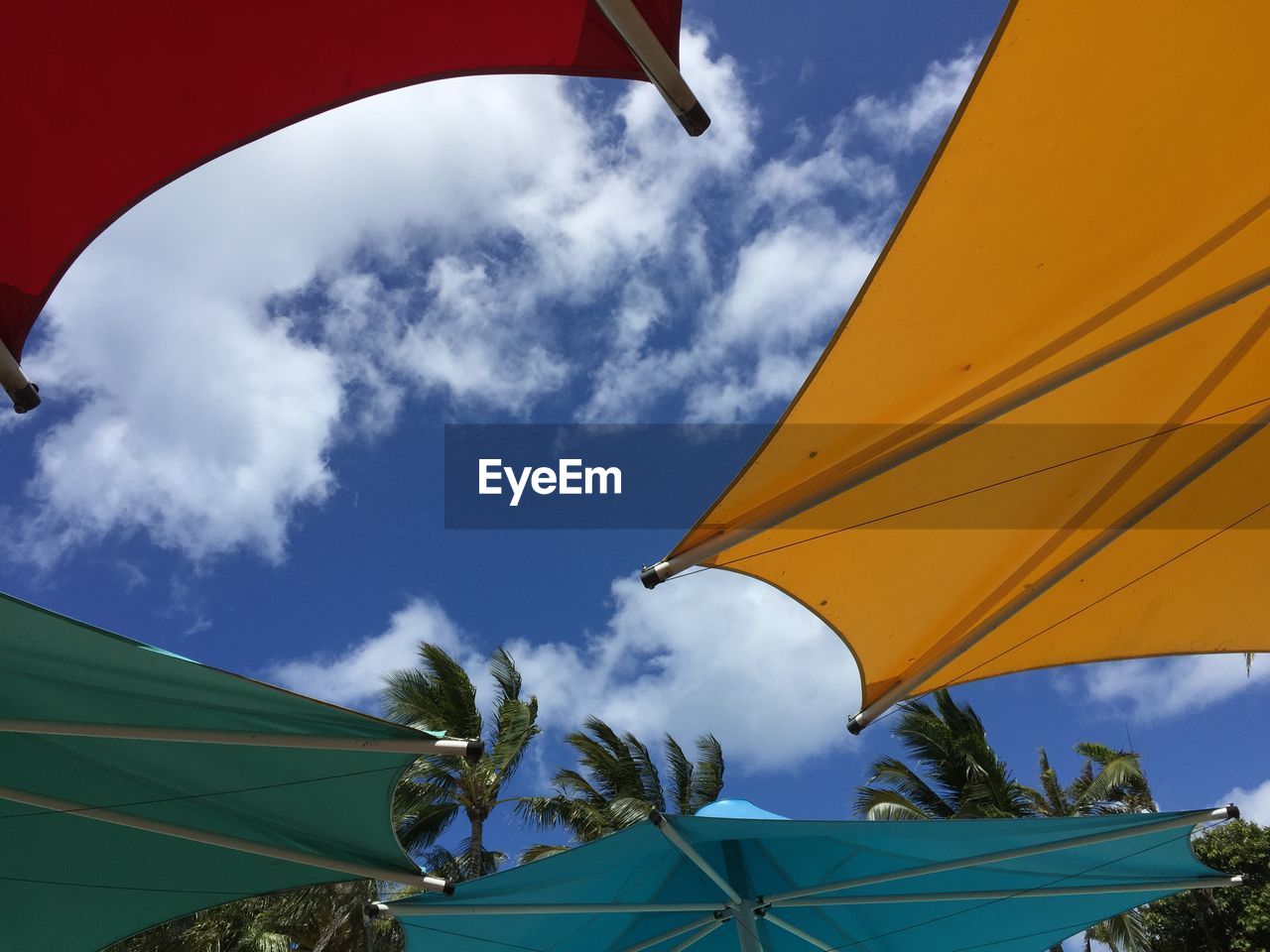 Low angle view of colorful parasols against sky