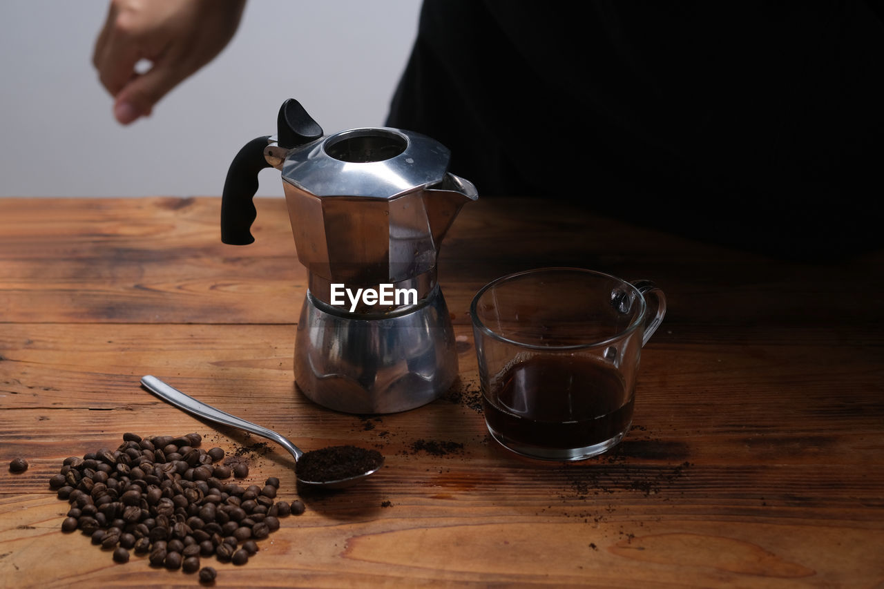 CLOSE-UP OF COFFEE CUP ON TABLE AGAINST WALL