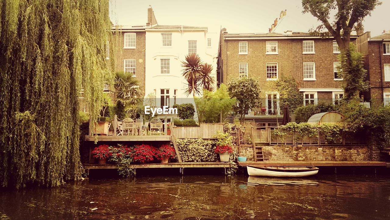 Boat moored in front of buildings against clear sky