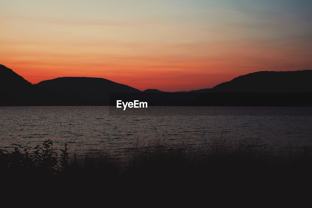 Scenic view of lake against sky during sunset