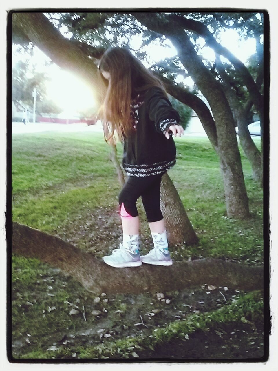 WOMAN STANDING ON GRASSY FIELD IN PARK