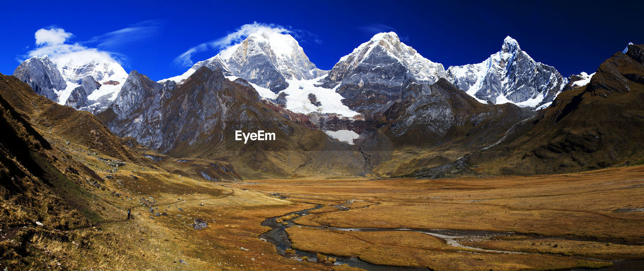 Panorama of snowy mountains and valley of rivers in the remote cordillera huayhuash circuit in peru.