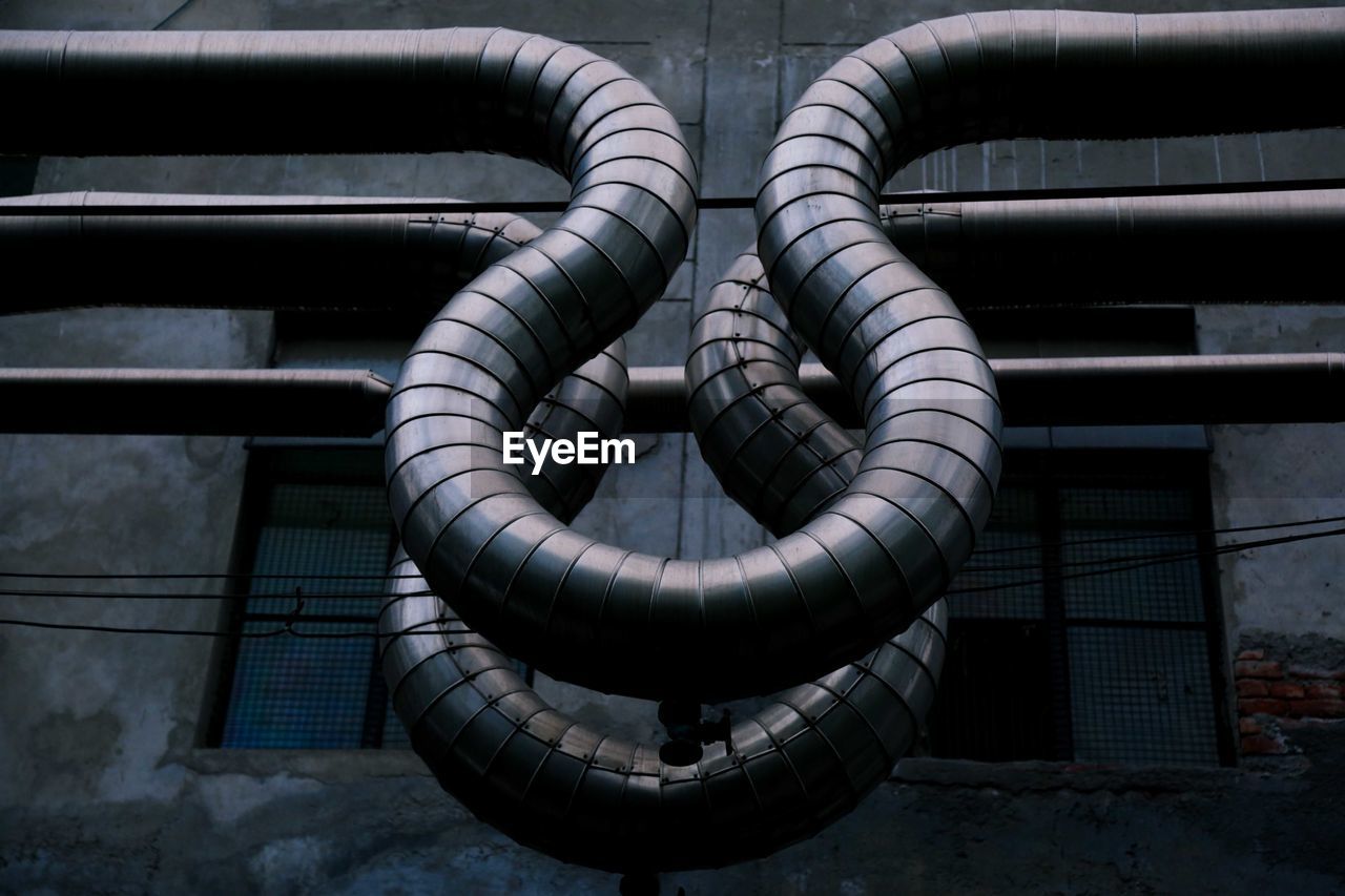 Low angle view of air ducts against old factory