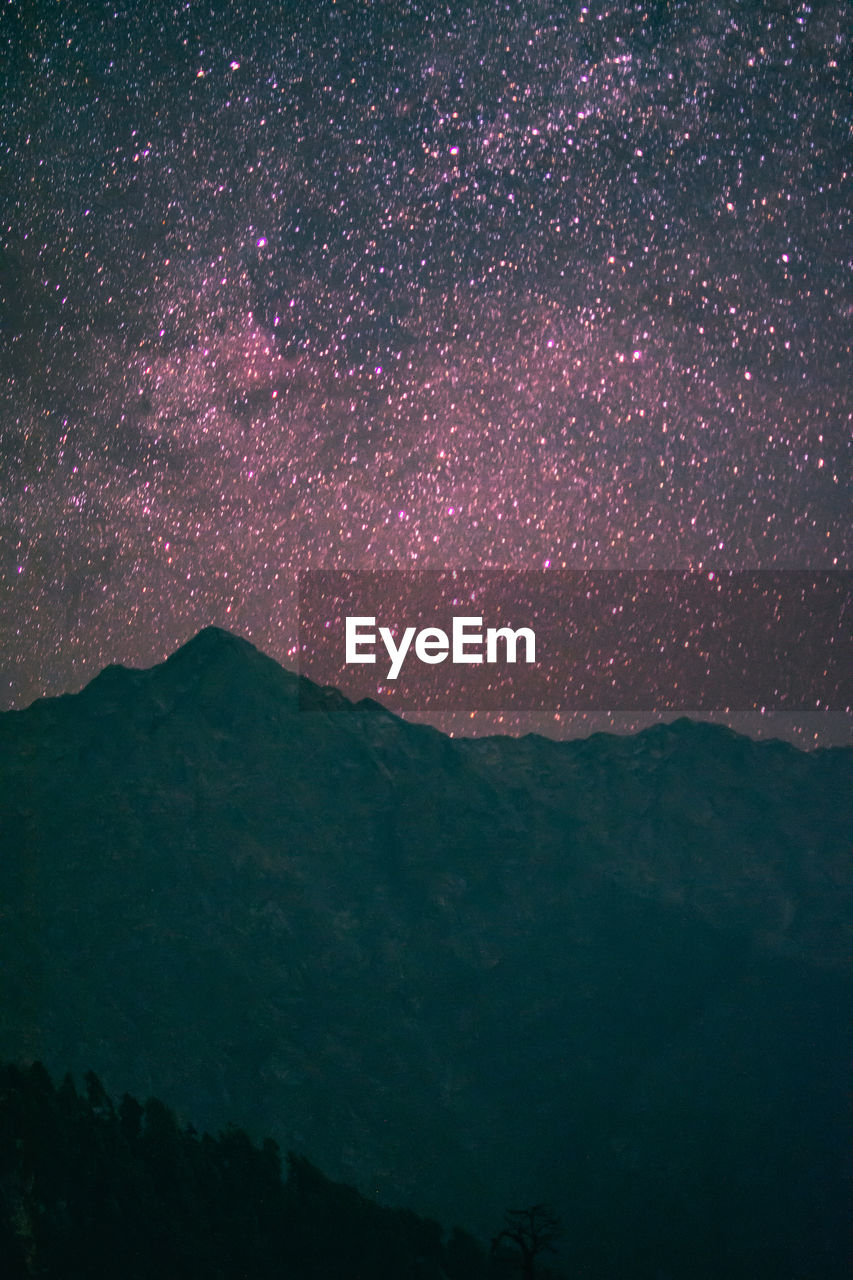 Scenic view of mountains against sky at night