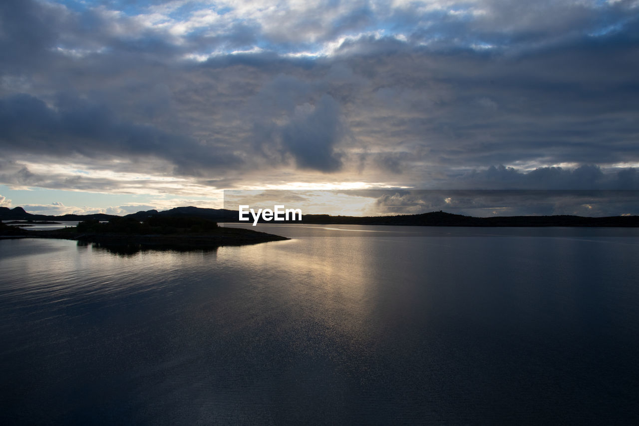 water, reflection, cloud, sky, horizon, sea, scenics - nature, dawn, beauty in nature, nature, environment, morning, sunlight, tranquility, no people, landscape, sunrise, ocean, dramatic sky, coast, tranquil scene, mountain, land, beach, outdoors, body of water, travel destinations, cloudscape, seascape, travel, bay, light