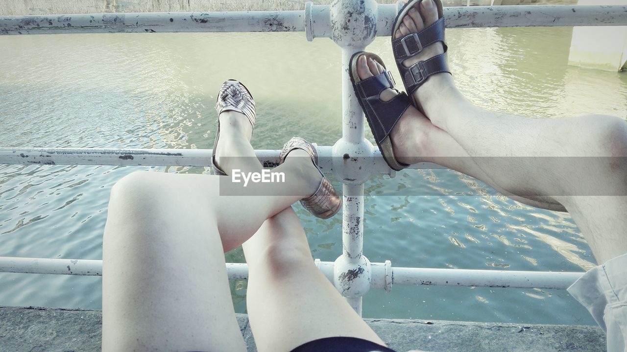 LOW SECTION OF PEOPLE SITTING ON SWIMMING POOL