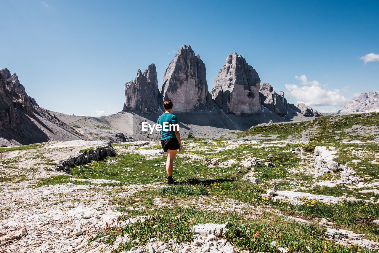 Rear view of a woman looking at  tre cime di lavaredo in the dolomites