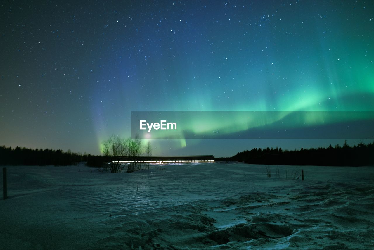 Scenic view of countryside against sky at night during winter