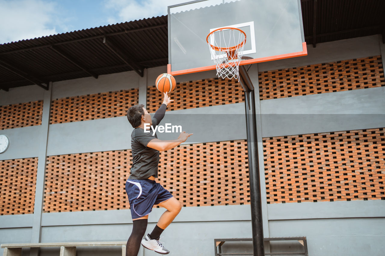 Low section of boy playing with basketball hoop