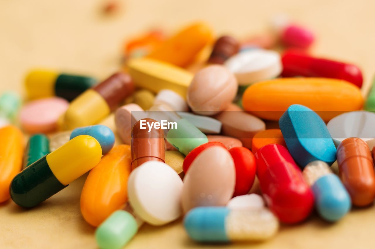 Close-up of multi colored medicines on beige background