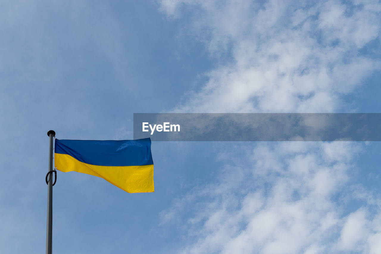 low angle view of flag against blue sky