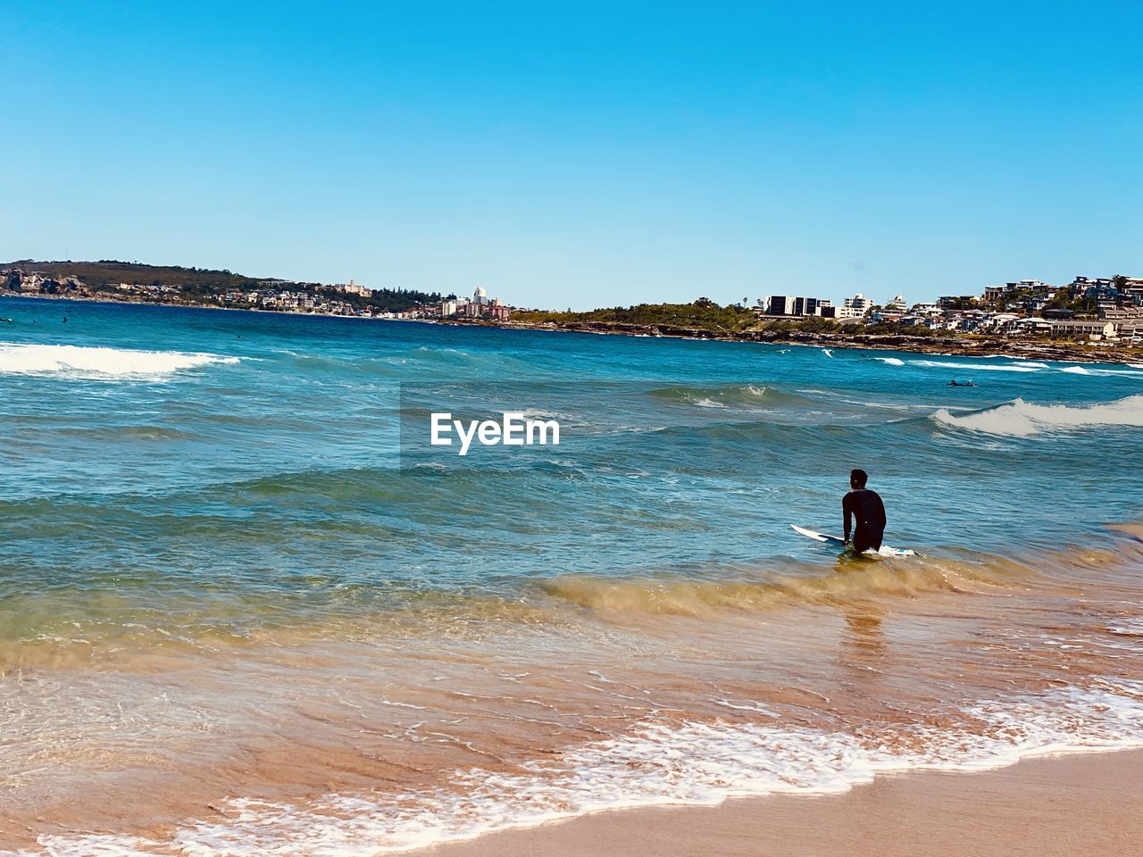 PEOPLE AT BEACH AGAINST CLEAR SKY