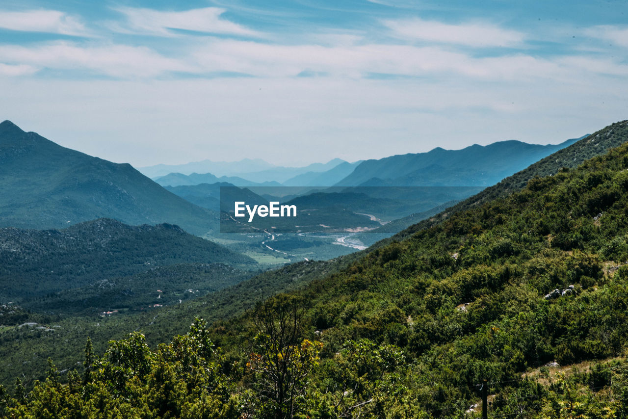 Scenic view of mountains against cloudy sky