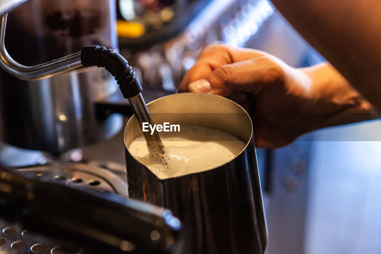 CLOSE-UP OF HAND POURING COFFEE