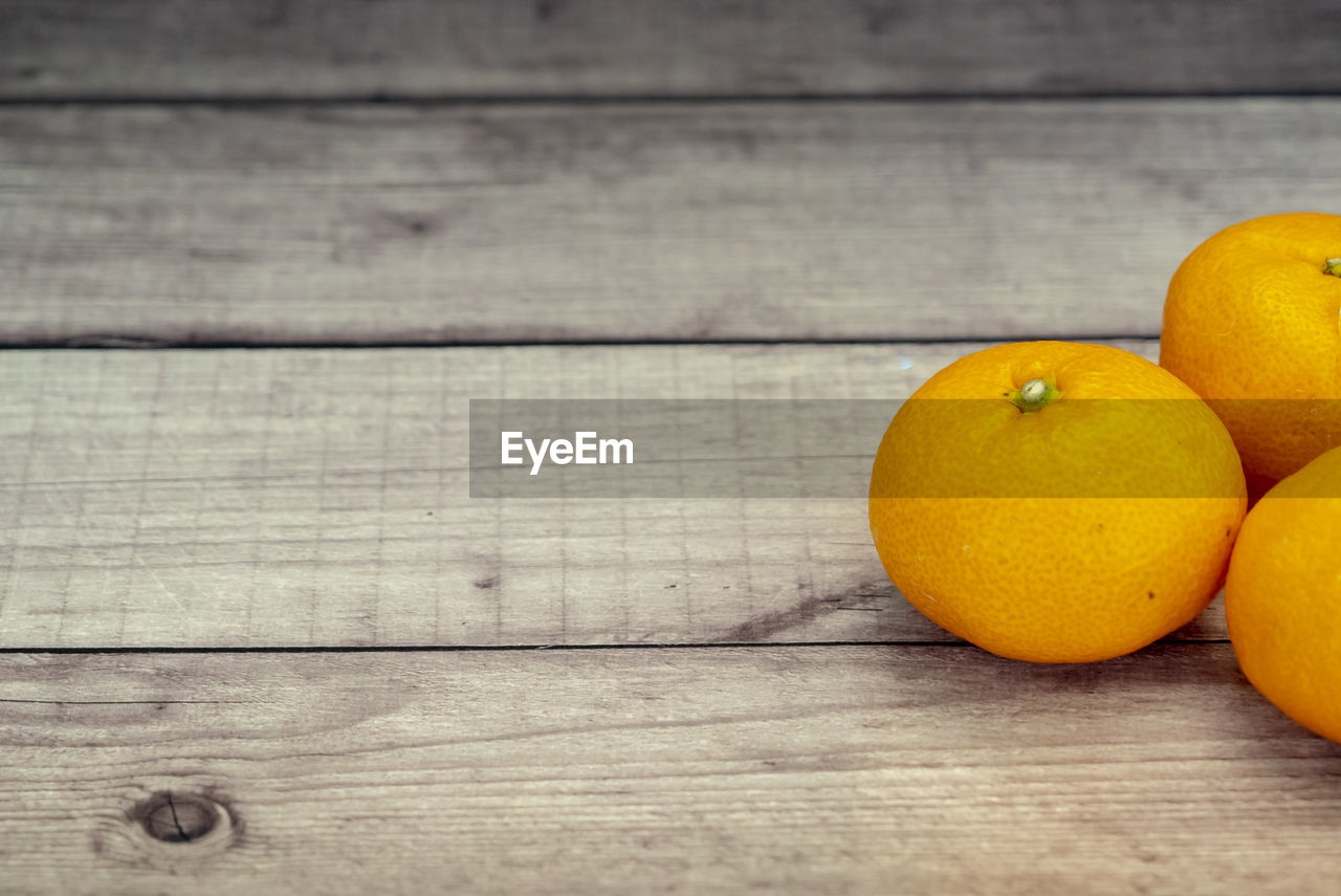 Orange fruit on wooden table background.