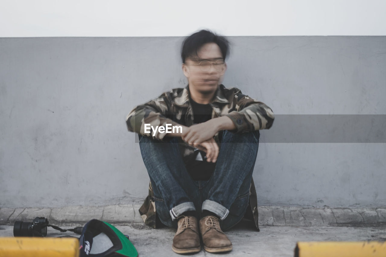 Blurred motion of man sitting outdoors