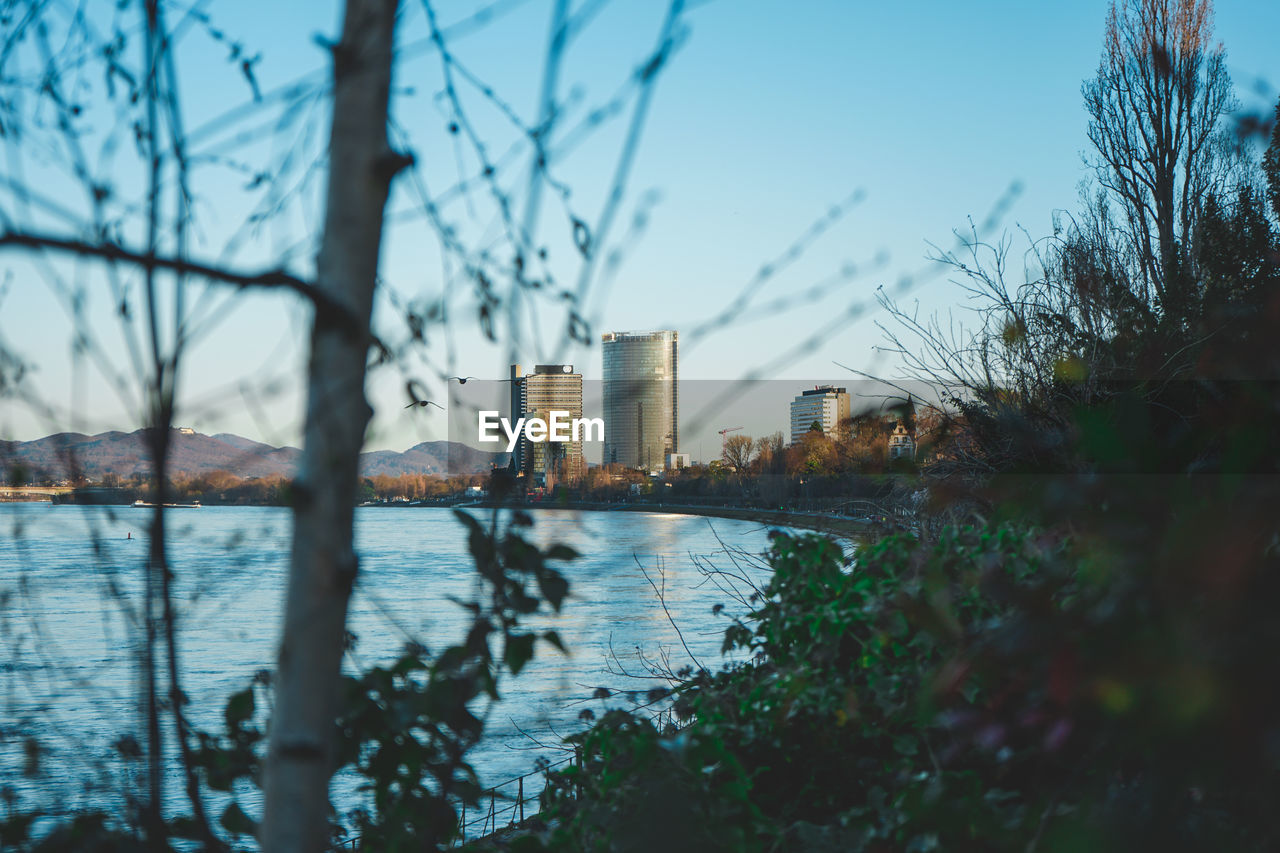 RIVER BY BUILDINGS AGAINST SKY