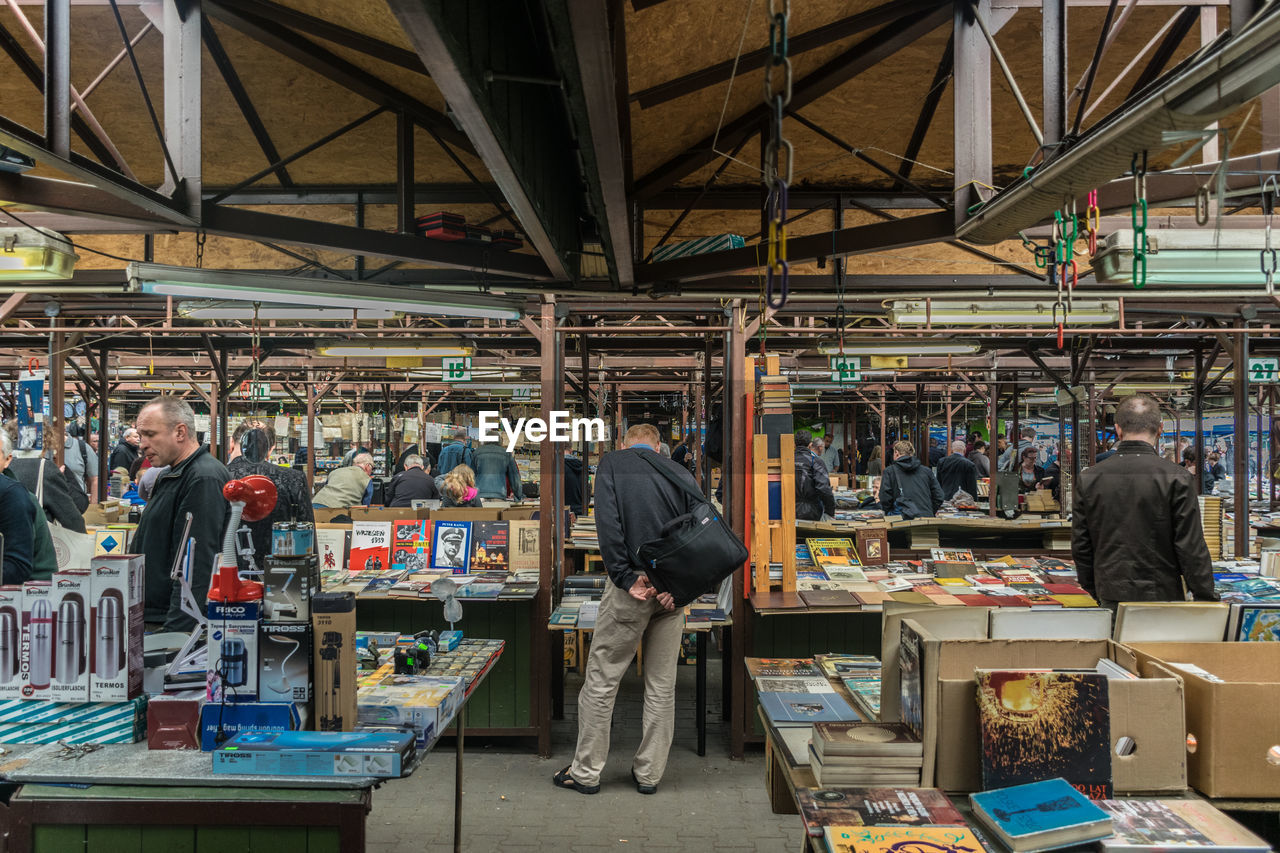 PEOPLE STANDING AT MARKET STALL