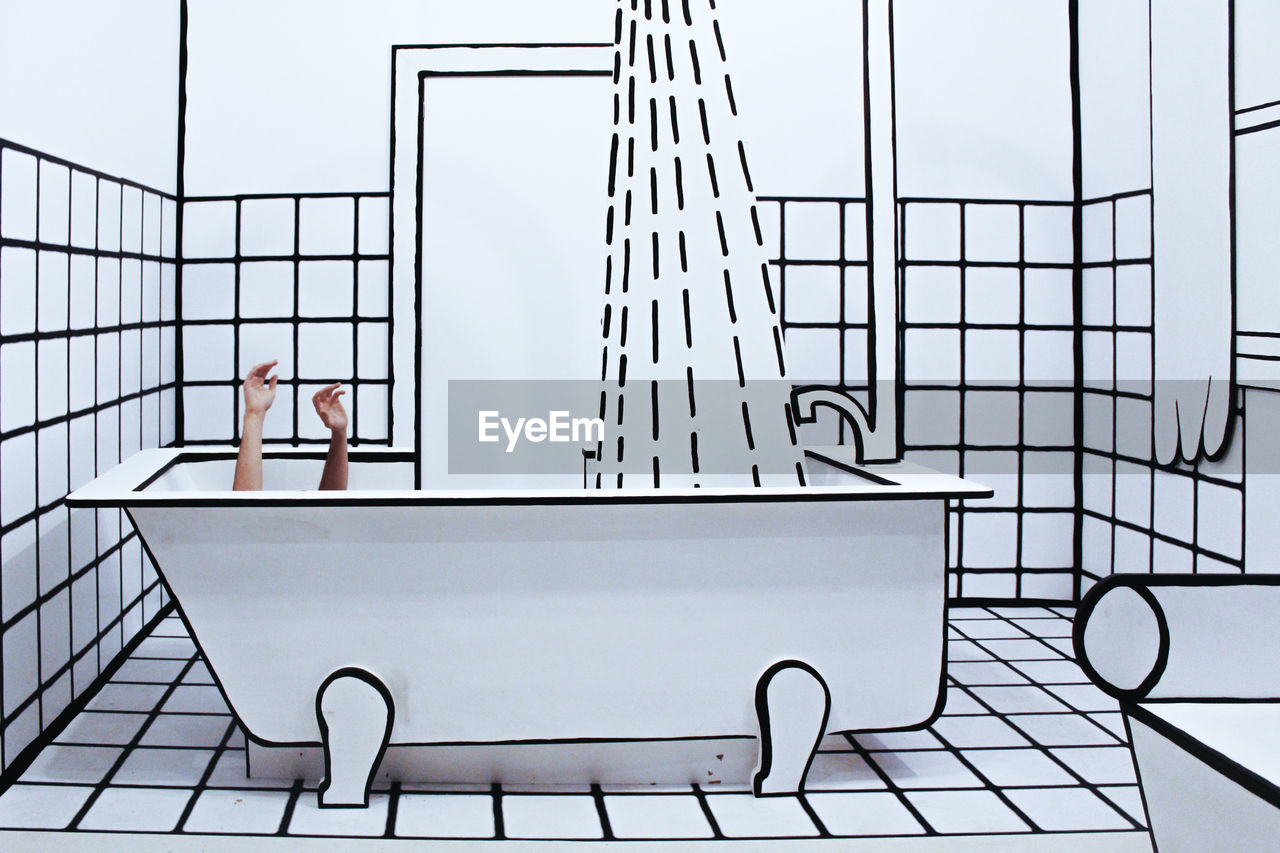 Digital composite image of hands coming out of bathtub in bathroom