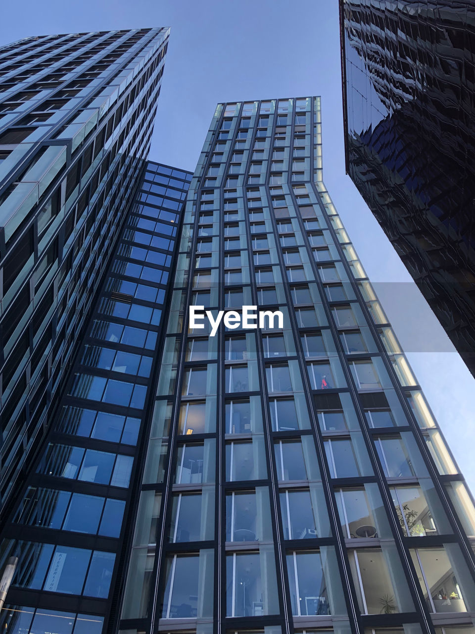 Low angle view of modern glass building against sky