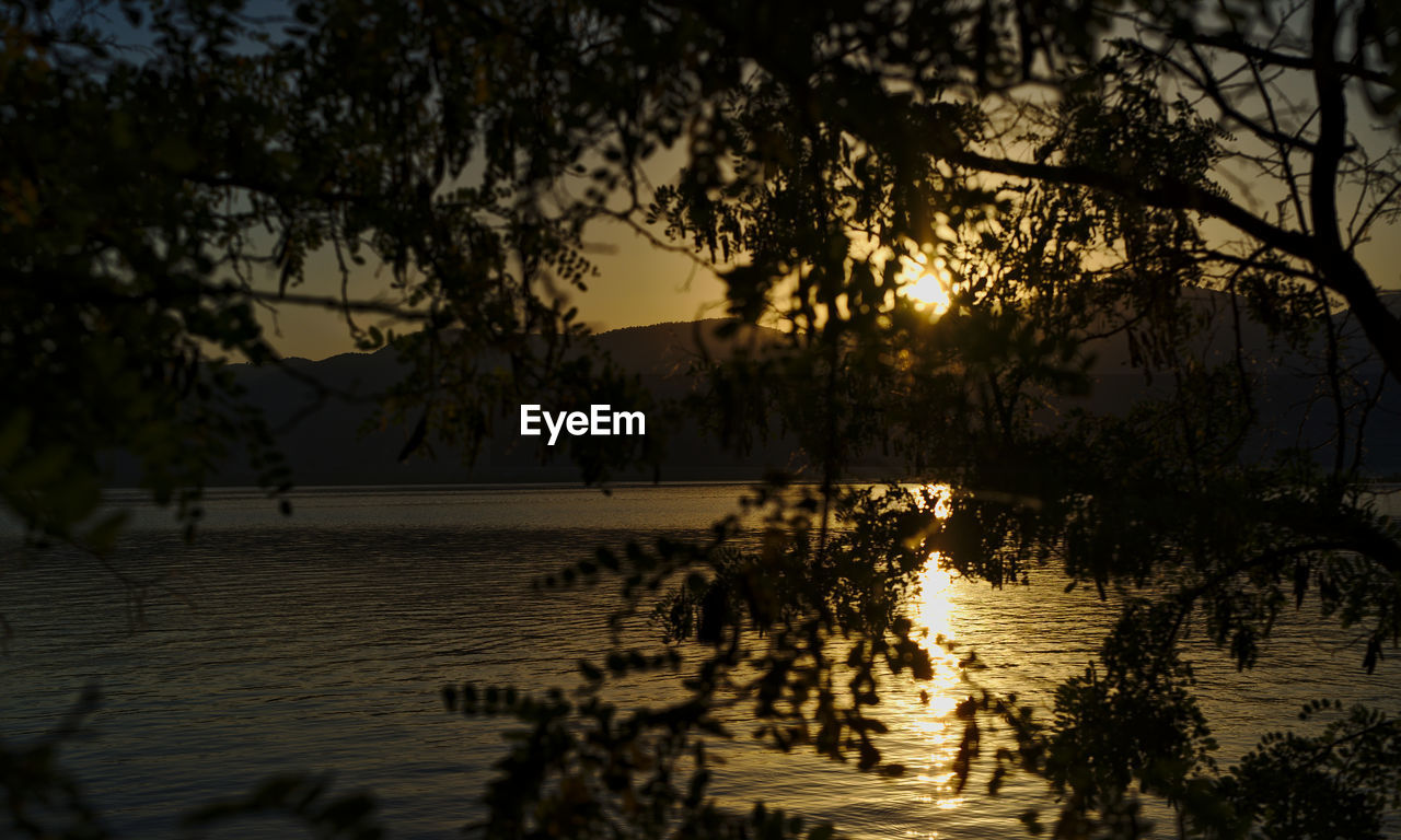 Scenic view of lake against sky at sunset