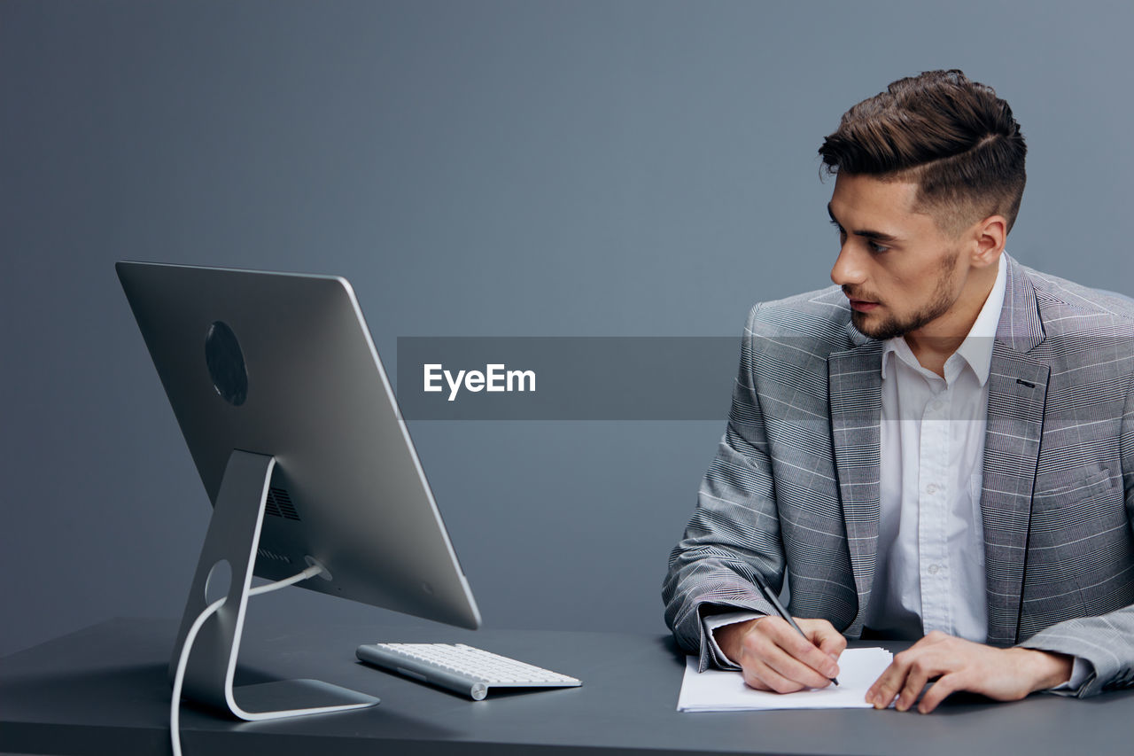 Young man using laptop while sitting on table