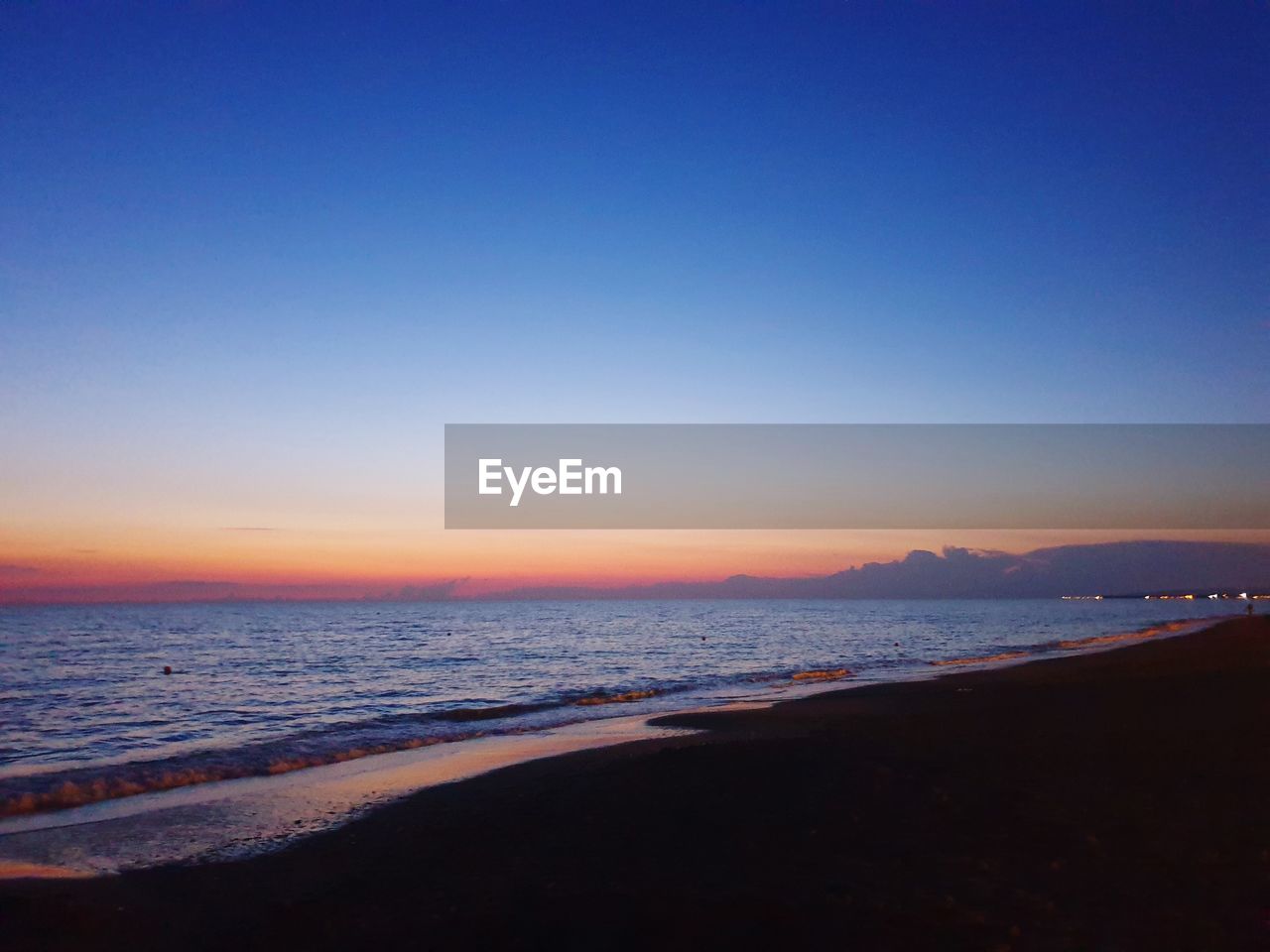 SCENIC VIEW OF BEACH AGAINST CLEAR SKY AT SUNSET