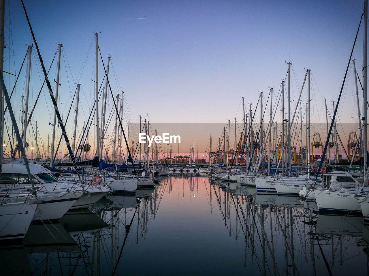 SAILBOATS MOORED AT HARBOR