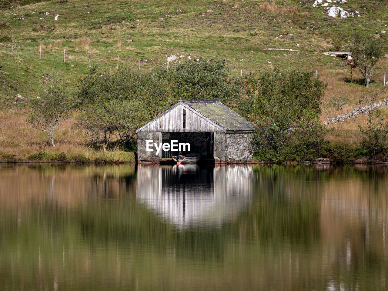 BUILT STRUCTURE BY LAKE AGAINST TREES