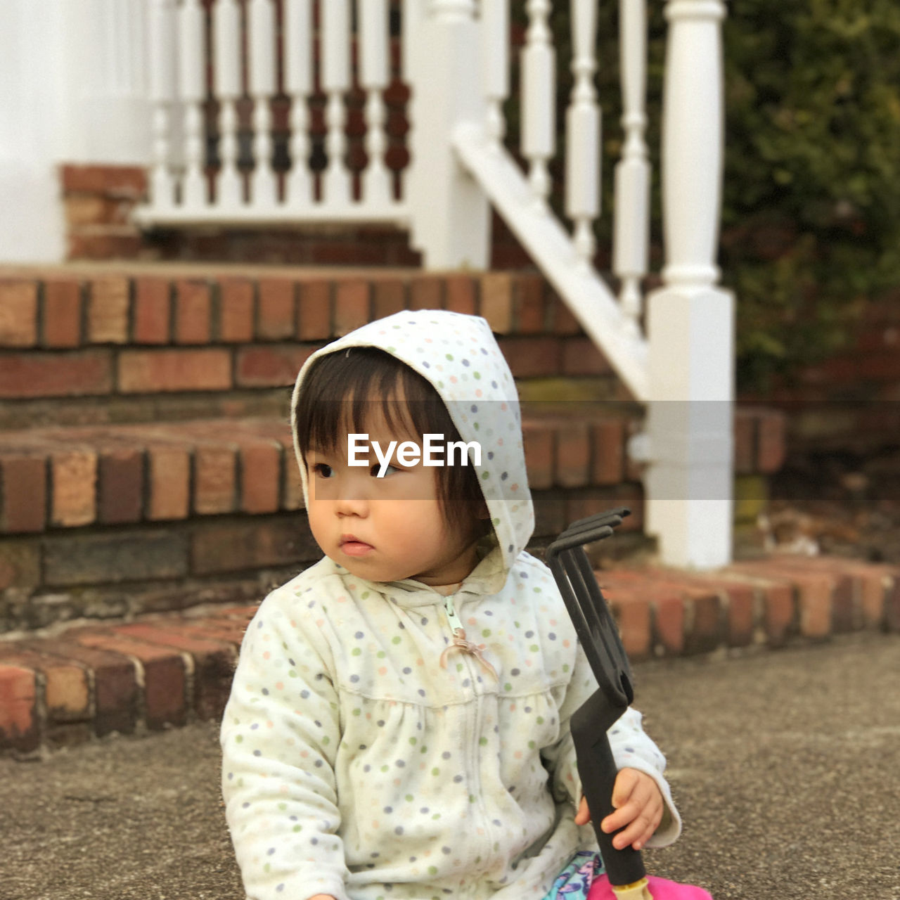 Portrait of a girl holding gardening rake