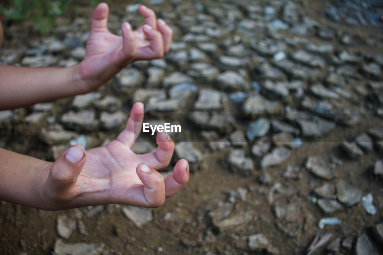 Cropped hands gesturing against field