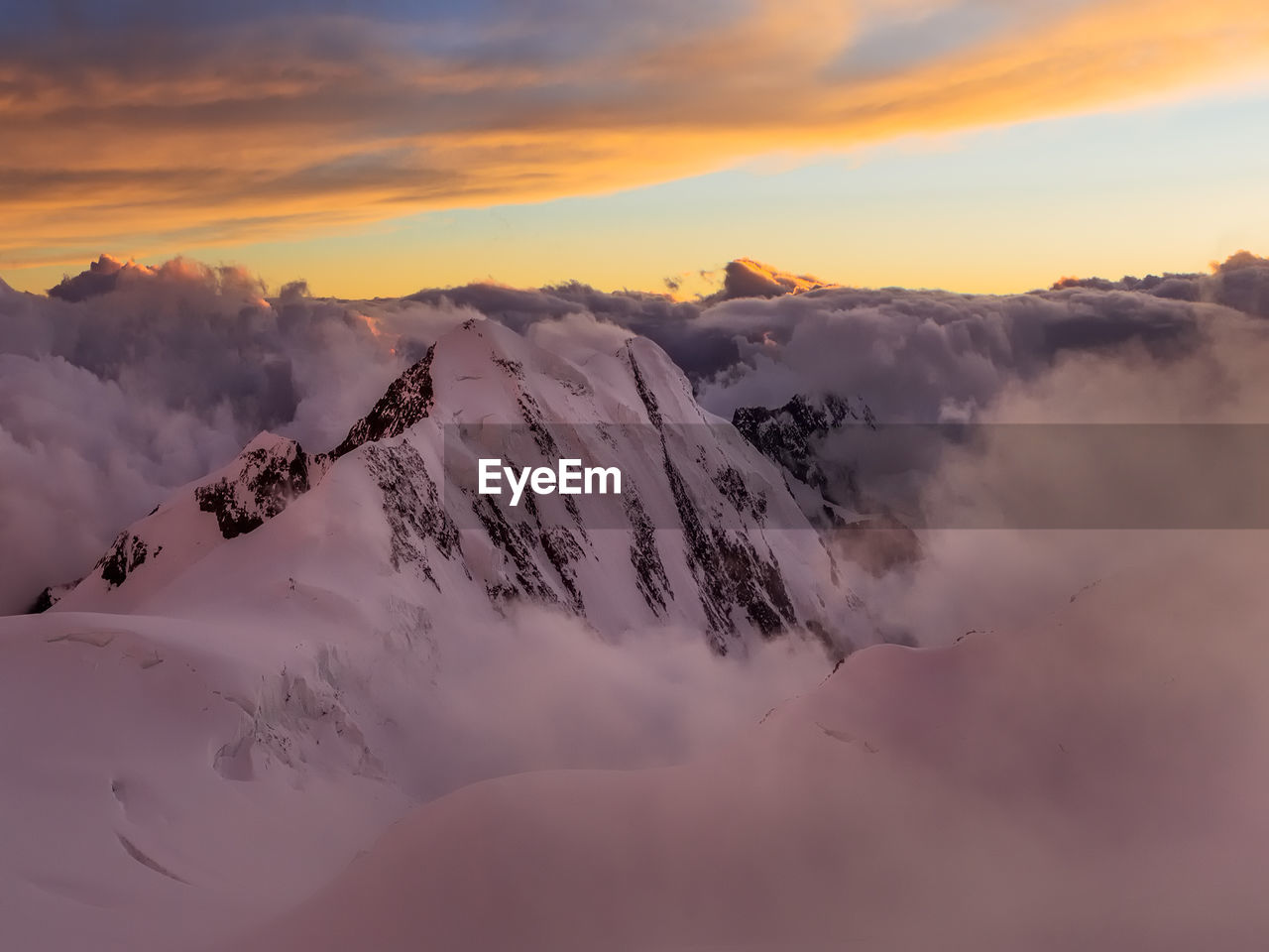 Scenic view of snow covered mountains against sky during sunset