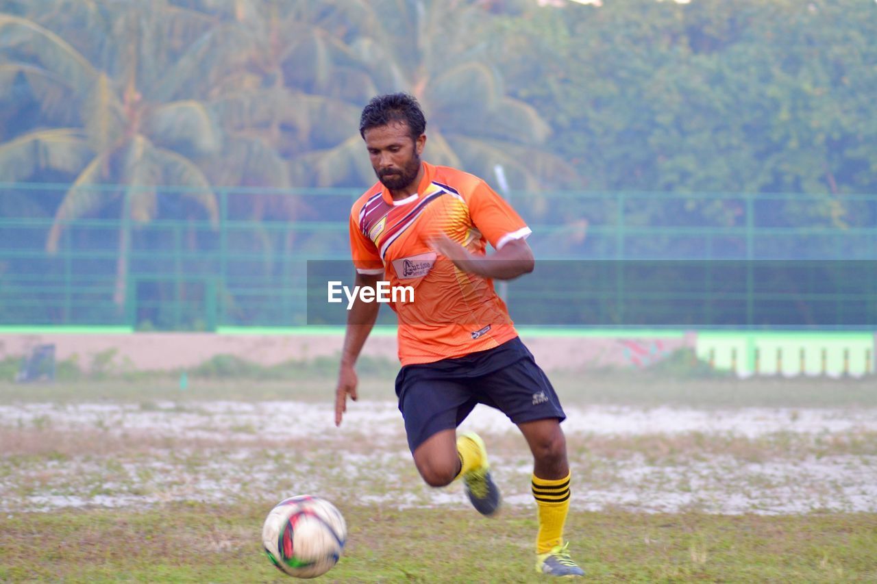 MAN PLAYING SOCCER ON FIELD