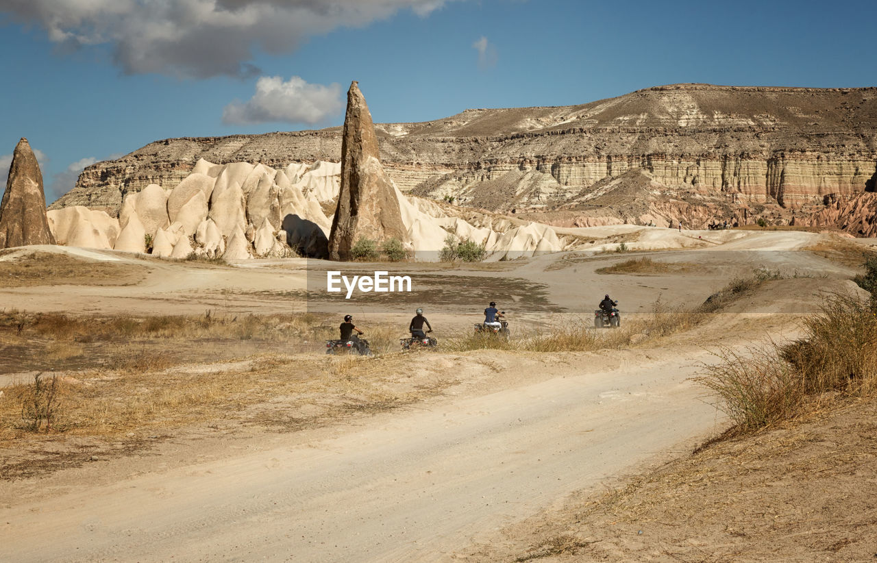 Men riding quadbike at desert