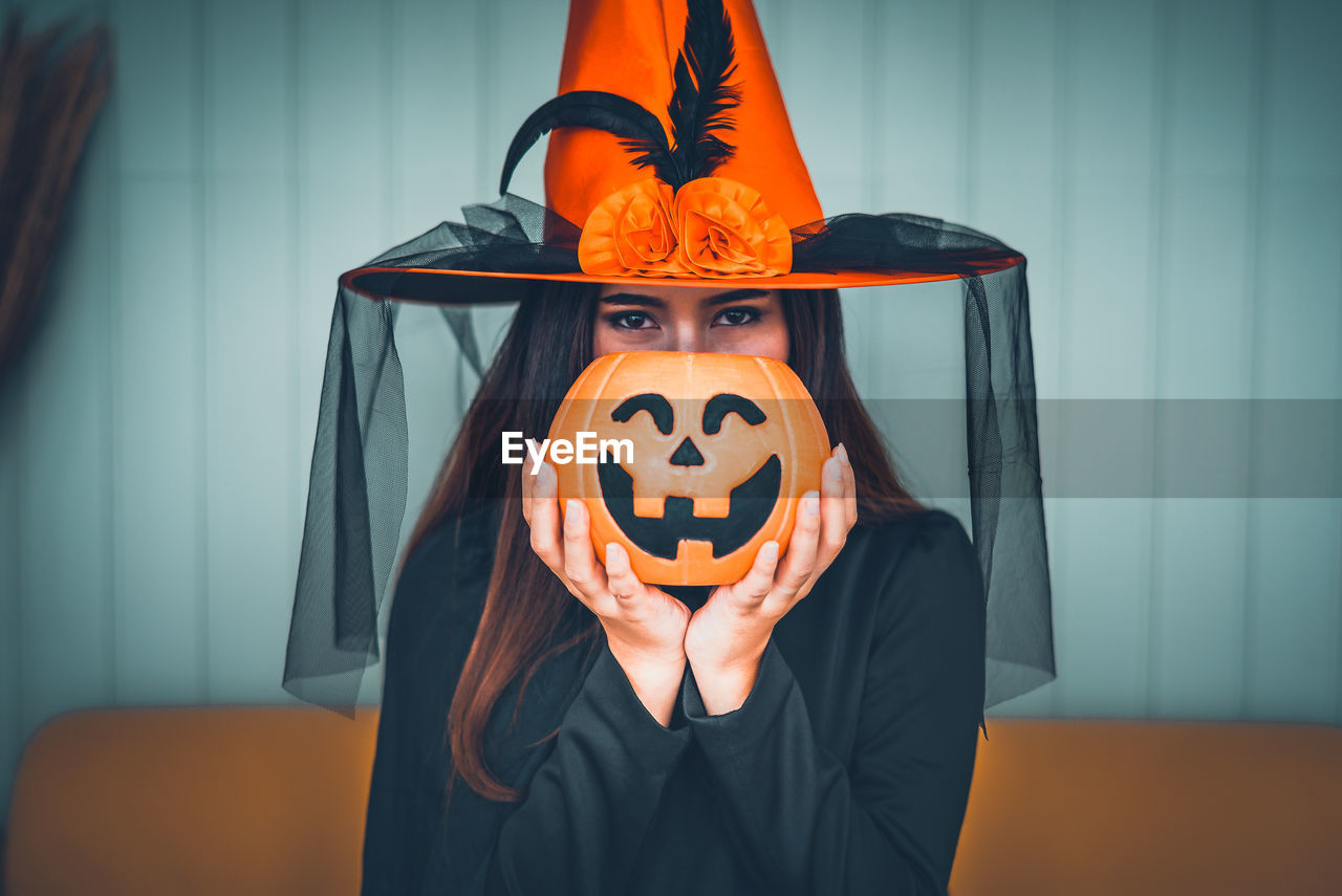 PERSON STANDING BY PUMPKIN ON A HALLOWEEN